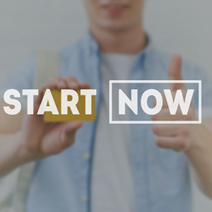 blurred image of a man holding up a business card on the left and a thumbs up on the right with the words 'start now' in the foreground unblurred